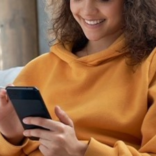 Happy,Millennial,Hispanic,Teen,Girl,Checking,Social,Media,Holding,Smartphone