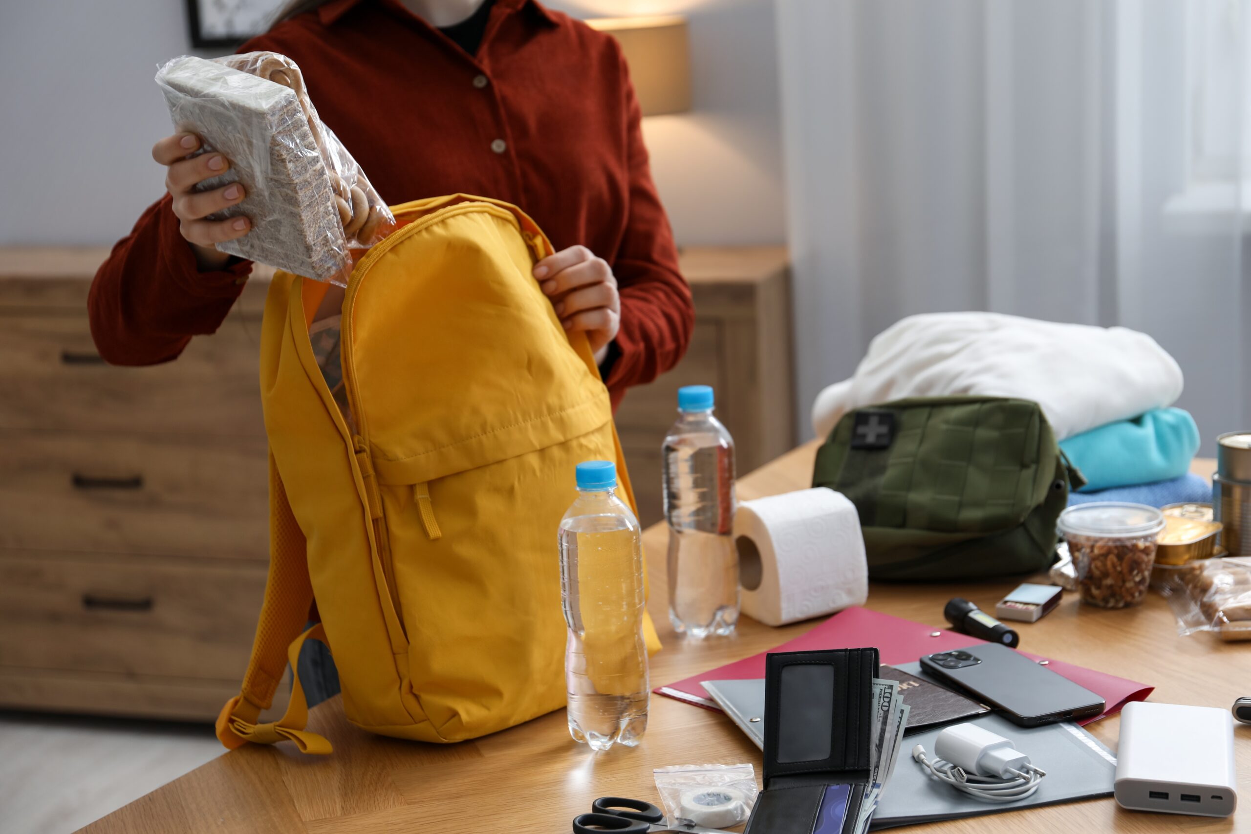 Survival,Kit.,Woman,Packing,Different,Emergency,Supplies,Into,Backpack,At